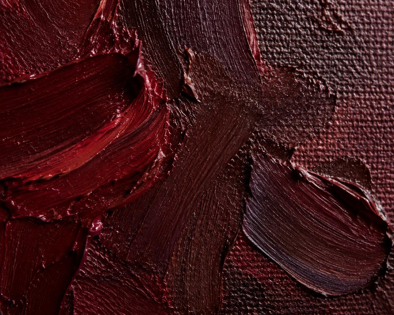 Close view of thick burgundy brushwork on canvas